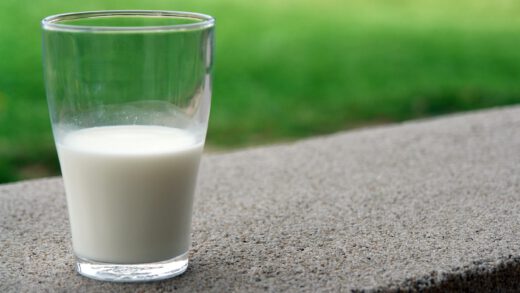 Pół szklanki mleka, stojąca na murku w ogrodzie