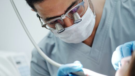 Mężczyzna pracuje jako dentysta i kontroluje zęby swojemu pacjentowi